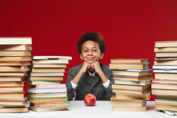 istock Cute Schooplboy at Desk with Books 1225545048