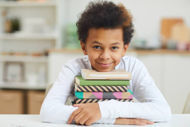 istock Cute African Boy Holding Books 1225545059