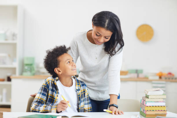 istock Smiling African Boy doing Homework with Mom 1225545071