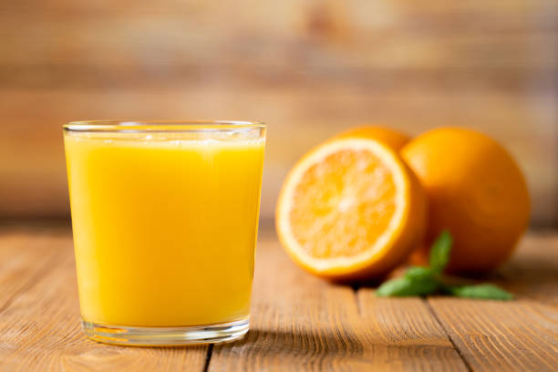 toma de jugo de naranja fresco en un vaso - zumo de naranja fotografías e imágenes de stock