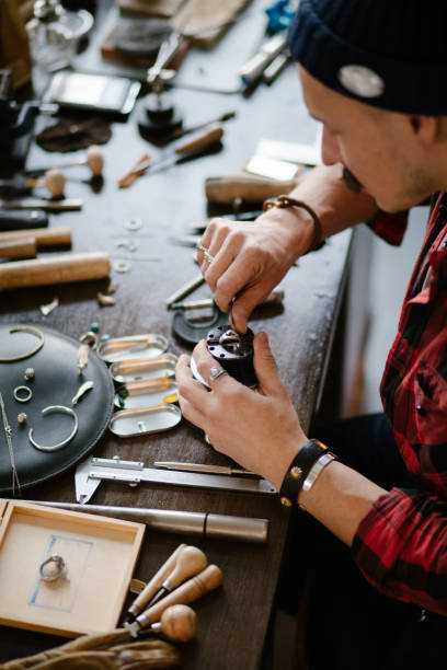 istock man replacing the jewel while sitting at the table in the workshop 1225547320