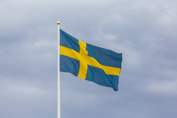 istock Swedish flag as proudly fluttering in the wind against a blue sky 1225547526