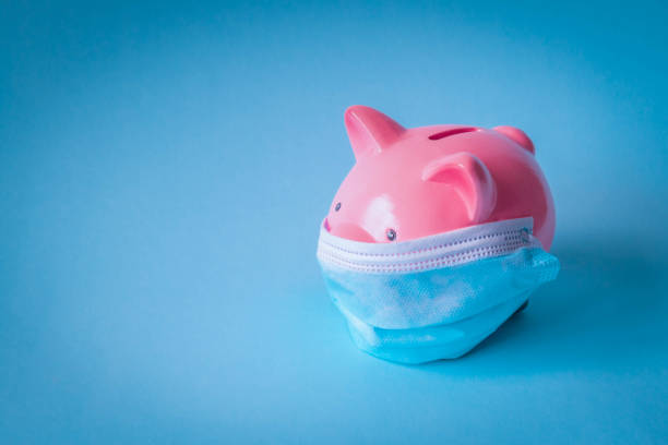 Piggy bank with protective face mask on isolated background stock photo