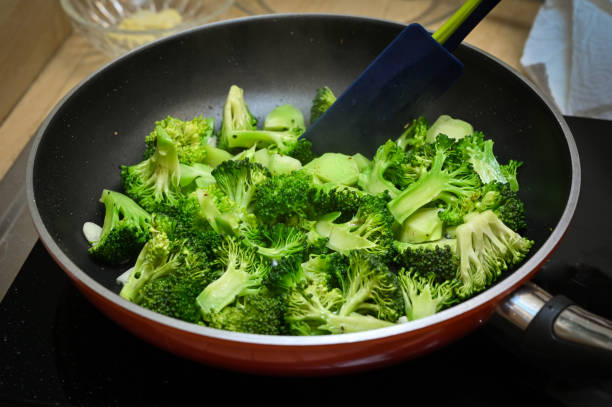 mexa brócolis frito com alho - cozinheiro doméstico - non stick - fotografias e filmes do acervo