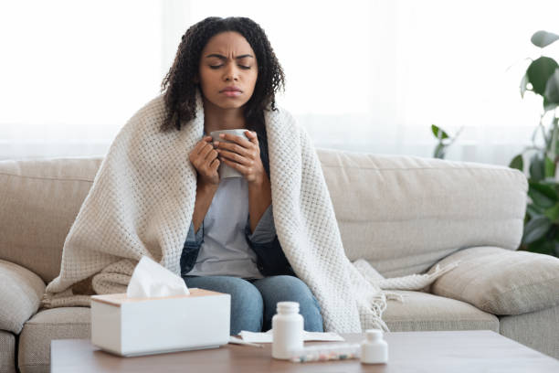 istock Sick Black Woman Feeling Unwell At Home, Drinking Tea On Couch 1225551351