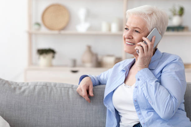 istock Modern Communication. Smiling elderly woman talking on cellphone at home 1225552181