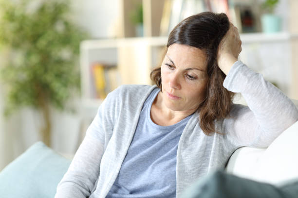 istock Sad pensive middle age woman looking down at home 1225552435