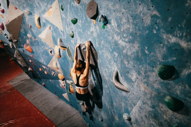 istock Strong muscular millennial woman on boulder climbing from above 1225552979