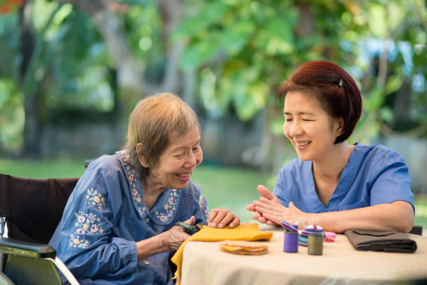 idosa com cuidadora na agulha faz terapia ocupacional para alzheimer ou demência - japanese ethnicity women asian and indian ethnicities smiling - fotografias e filmes do acervo