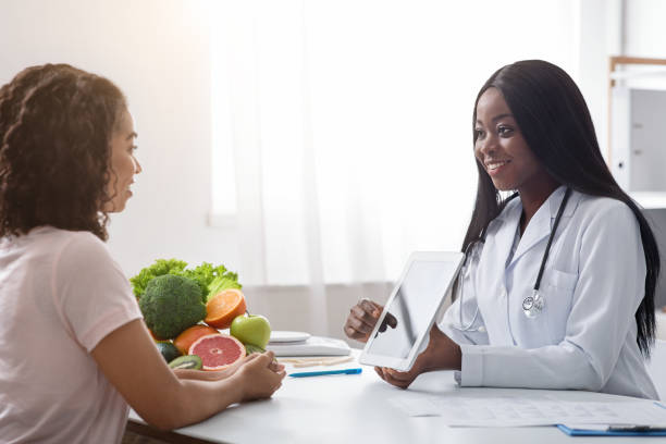 istock Woman nutritionist using digital tablet in office, consulting patient 1225554709