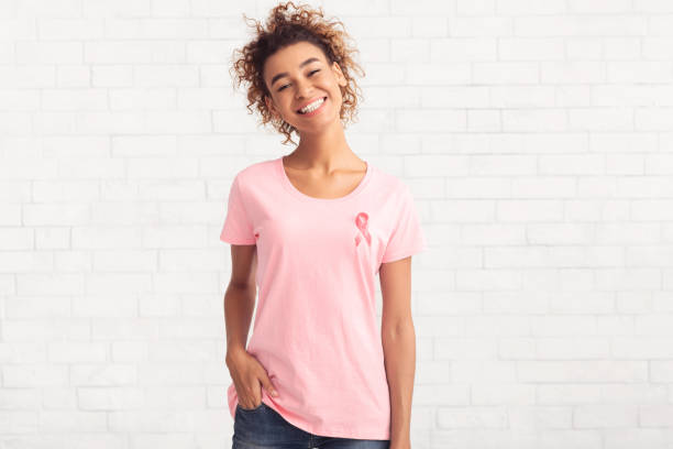 breast cancer volunteer girl smiling posing over white brick wall - t shirt shirt pink blank imagens e fotografias de stock