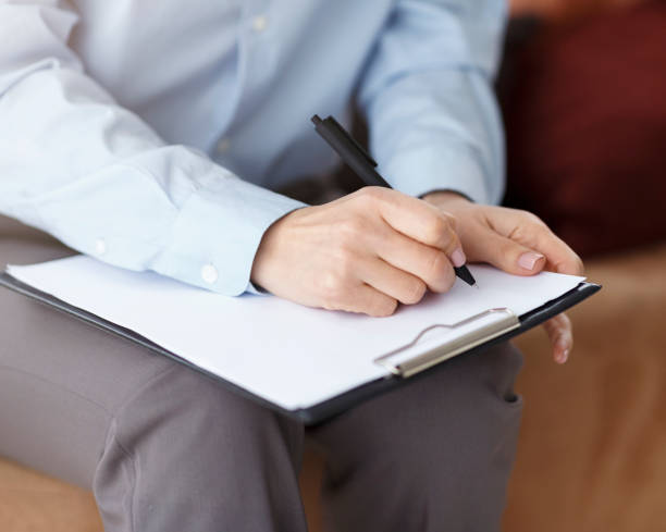 istock Unrecognizable Professional Psychologist Taking Notes Sitting On Couch In Office 1225555021