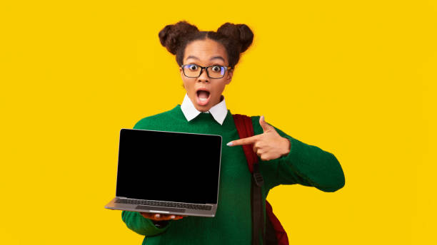 Happy afro girl pointing at blank laptop screen New Website. Excited black teenager girl showing laptop with blank screen, pointing finger, mock up, panorama nerd sweater stock pictures, royalty-free photos & images