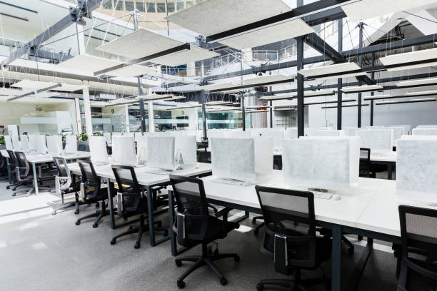 istock Big empty rental office for IT workers with wrapped in cover computers 1225557507
