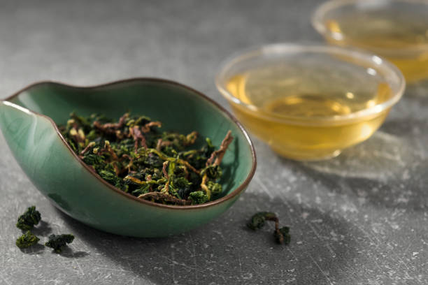 Oolong chinese tea leaves and hot drink Dry tea leaves and hot drink in asian style cups. Oolong chinese tea in cha he sri lankan culture photos stock pictures, royalty-free photos & images