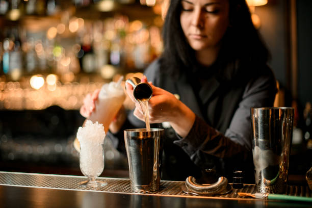 istock brunette barman gently pours the drink into steel shaker using beaker 1225558948