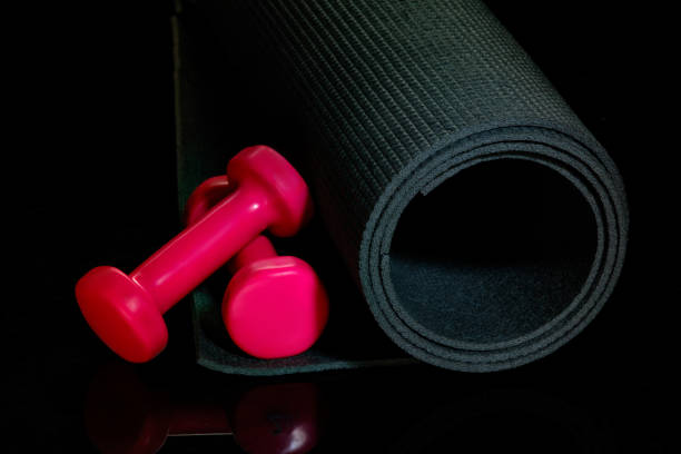 istock Professional sport equipment isolated on black studio background. Exercise mat and weights. 1225560435