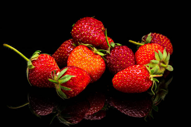istock fresh red strawberries isolated on a black background, fresh from the garden 1225566578