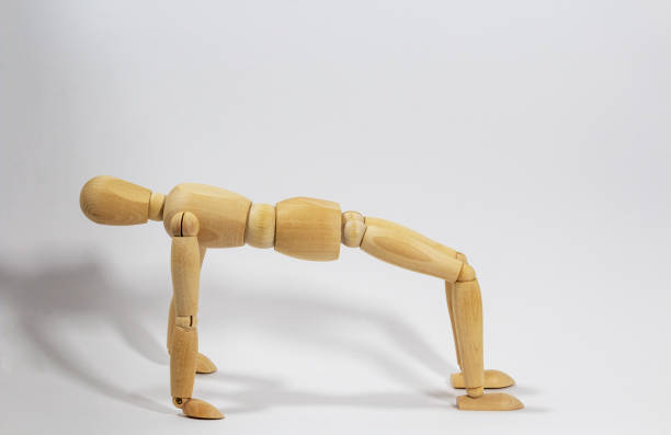 istock wooden doll for yoga exercise Ansanas, the exercise table, against white background 1225567560