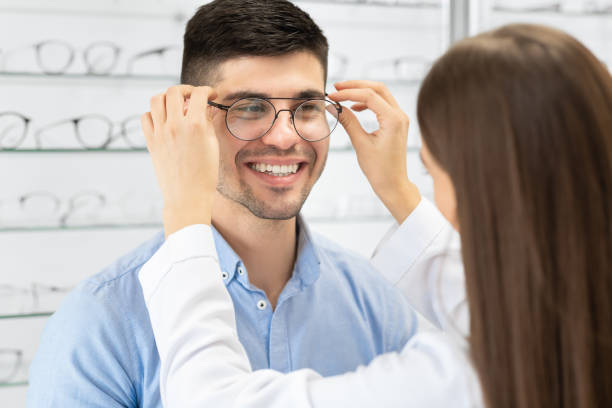 istock Optometrist helping young man to choose correction glasses 1225568491