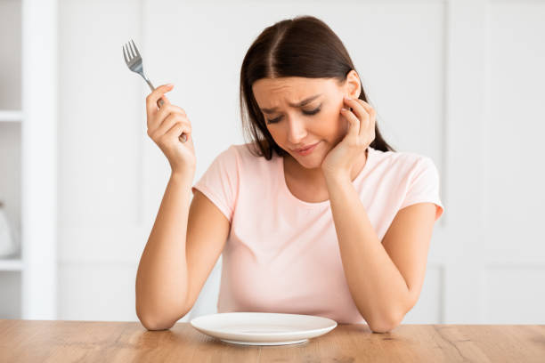 istock Hungry Girl Looking At Empty Plate On Table At Home 1225568707