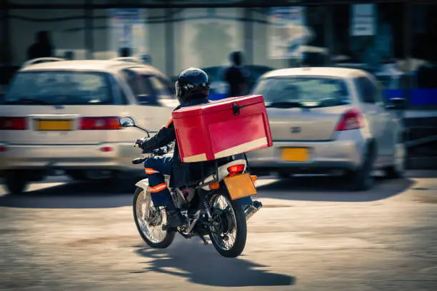 African people  delivery man on a motorcycle, urban scene