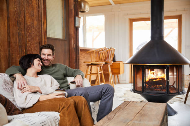 istock Laughing young couple drinking tea and relaxing by a fire in their cabin 1225573702