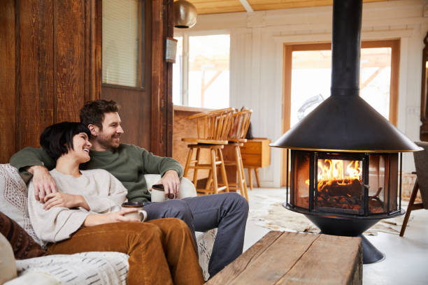istock Smiling young couple drinking tea and relaxing by a fire in their cabin 1225573908