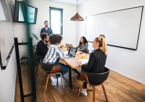 istock Young Businessman Presenting Slide Show Brief to Colleagues 1225575989