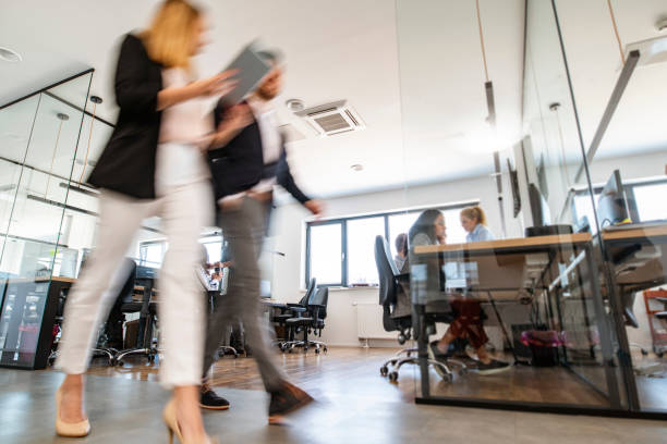 istock Young Business Colleagues Walking Through Open Plan Office 1225576072