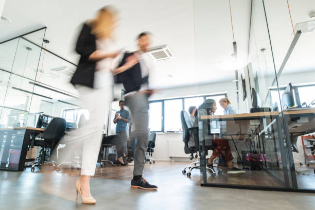 istock Young Business Colleagues Walking Through Open Plan Office 1225576078