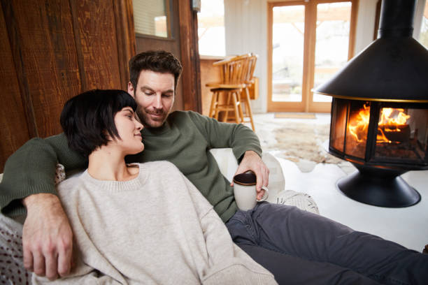 istock Young couple talking over tea while warming up by their cabin fireplace 1225576573