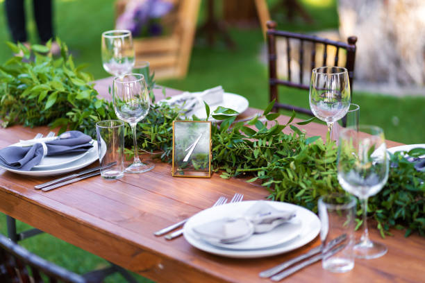 istock Preparing for an open-air party. Decorated with fresh flowers served tables. Table number. Decoration Details 1225578039