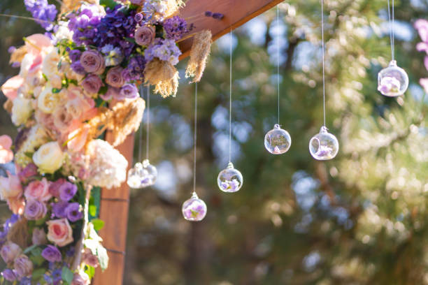 decoración de primer plano con flores frescas de locales. arco de boda decorado con flores frescas y bolas de vidrio colgantes - wedding venue fotografías e imágenes de stock