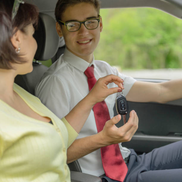 指定ドライバ。女性はプロの運転手に鍵を与えます。サービスは地味なドライバーです。 - designated driver ストックフォトと画像