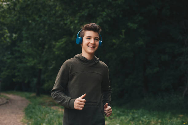 jeune homme beau courant dans la nature. - beautiful caucasian teenager running photos et images de collection