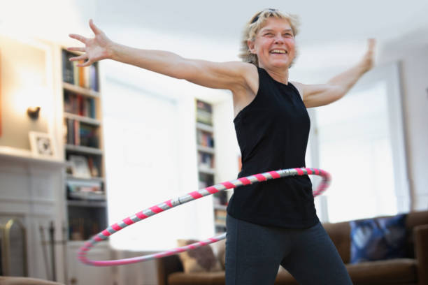 Mature woman exercising inside the house stock photo