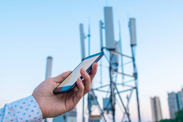 istock Men hand using phone with 5G telecommunications station tower background 1225586169