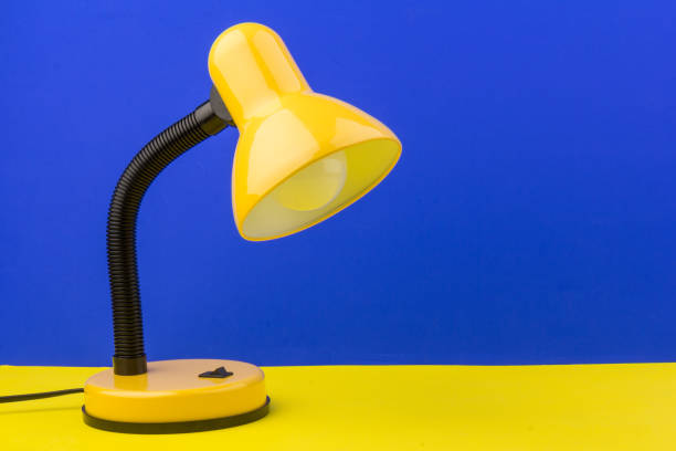 istock Yellow desk lamp isolated on yellow and blue background 1225586185