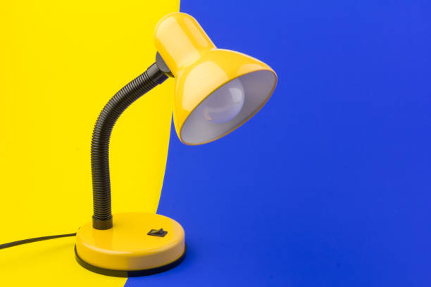 istock Yellow desk lamp isolated on yellow and blue background 1225586276