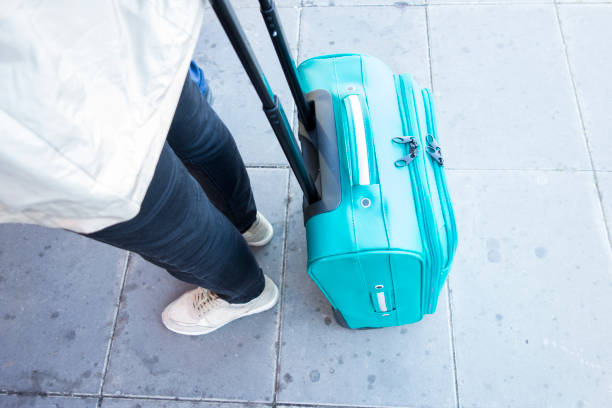 istock people dragging a travel suitcase 1225589038