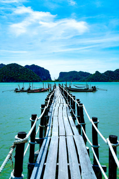 istock Old Wooden bridge into the sea. 1225589887