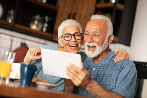 istock Senior couple smiling and looking at tablet 1225590631