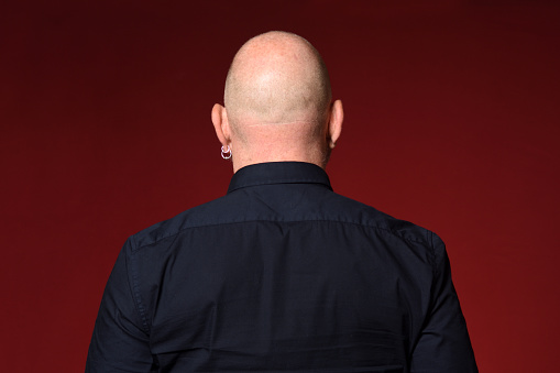 portrait of a bald man,rear view,on red background