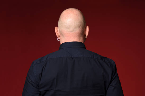Portrait of a man on red portrait of a bald man,rear view,on red background skin head stock pictures, royalty-free photos & images