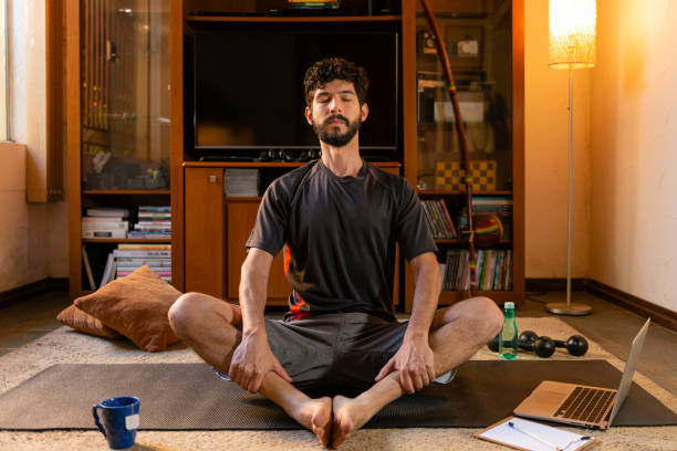 istock Young man performing meditation at his home. Yoga practice through online video classes 1225593106