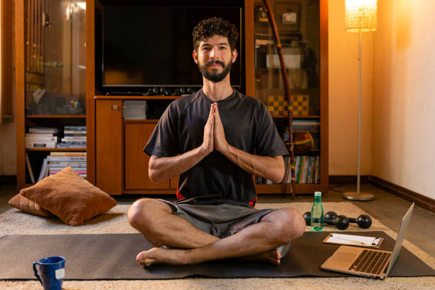 istock Man performing meditation at his residence. Yoga practice through online video classes 1225594333