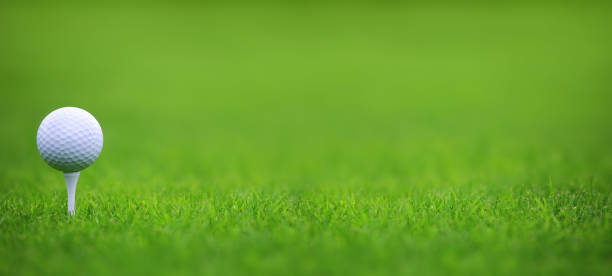golfball auf grünem grashintergrund - golf golf ball tee green stock-fotos und bilder