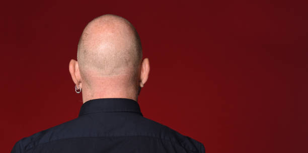 Portrait of a man on red portrait of a bald man back view on red background skinhead haircut stock pictures, royalty-free photos & images