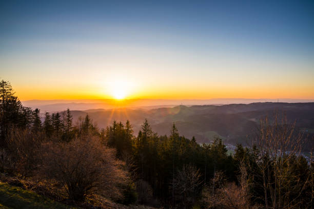 Germany, Romantic orange sunset sky with sunrays over vosges mountains nature landscape view from hoernleberg mountain at dawn
